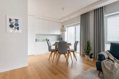 a kitchen and dining room with a table and chairs at D33 Vilnius - Brand New Luxury Apartment with Terrace, Garden, AC and Parking in Vilnius