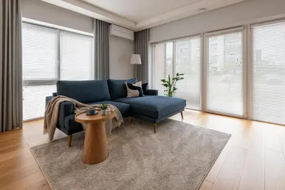 a living room with a blue couch and a table at D33 Vilnius - Brand New Luxury Apartment with Terrace, Garden, AC and Parking in Vilnius