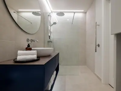 a bathroom with a sink and a mirror and a shower at D33 Vilnius - Brand New Luxury Apartment with Terrace, Garden, AC and Parking in Vilnius
