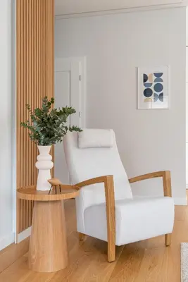 a living room with a white chair and a table at D33 Vilnius - Brand New Luxury Apartment with Terrace, Garden, AC and Parking in Vilnius