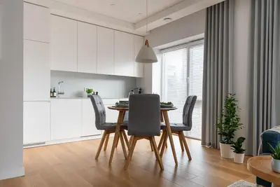 a kitchen and dining room with a table and chairs at D33 Vilnius - Brand New Luxury Apartment with Terrace, Garden, AC and Parking in Vilnius