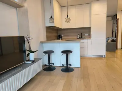 a kitchen with two stools and a counter in a room at Modern Urban Retreat & Private Parking in Vilnius