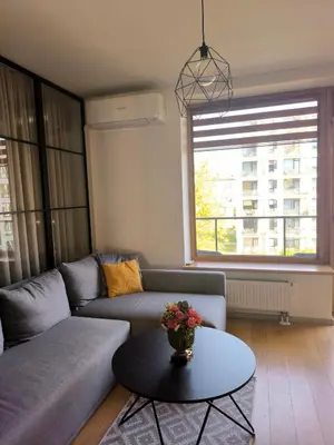 a living room with a couch and a table at Modern Urban Retreat & Private Parking in Vilnius