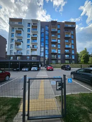 a parking lot in front of a large building at Milda's apartment Kaunas in Kaunas