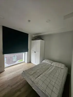 a bedroom with a bed and a large window at Milda's apartment Kaunas in Kaunas