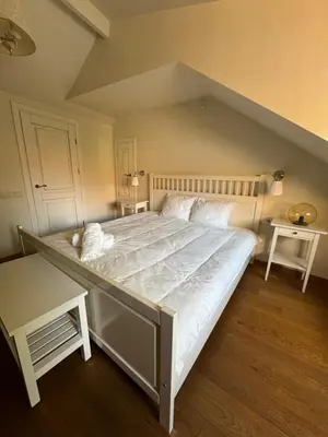 a large white bed in a room with two tables at Heart of Vilnius in Vilnius