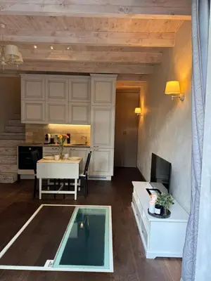 a living room with a table and a kitchen at Heart of Vilnius in Vilnius
