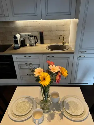 a vase of flowers on a table in a kitchen at Heart of Vilnius in Vilnius