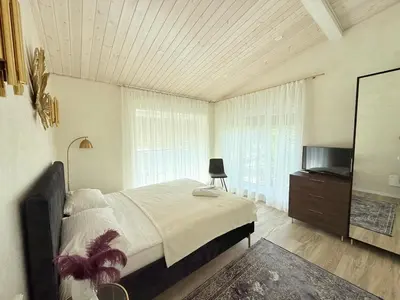 a bedroom with a large bed and a television at Vėjukai in Viduklė