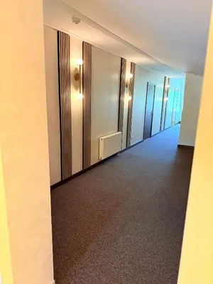 a hallway in a building with a large mirror at Vėjukai in Viduklė