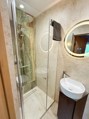 a bathroom with a shower and a sink and a mirror at Vėjukai in Viduklė