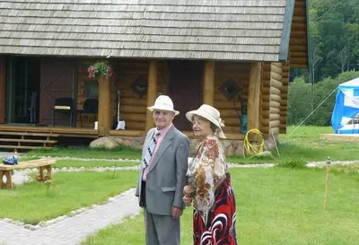 a man and woman standing in front of a cabin at Šnekučių kaimas in Miežonys