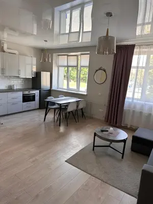 a living room with a table and a kitchen at Studio flat Centrinis Butukas in Kėdainiai