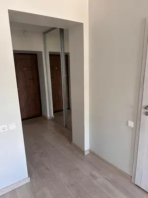 an empty room with two doors and wooden floors at Studio flat Centrinis Butukas in Kėdainiai