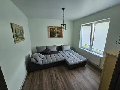 a living room with a couch in front of a window at Apartamentai keliaujantiems į Kauna in Garliava