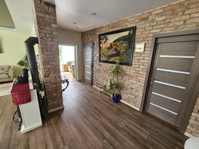 a living room with a brick wall and a door at Apartamentai keliaujantiems į Kauna in Garliava
