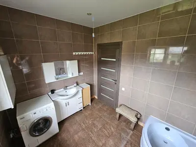 a bathroom with a washing machine and a sink at Apartamentai keliaujantiems į Kauna in Garliava