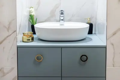 a bathroom with a white sink on a blue cabinet at One-Bedroom Traku Street Apartment by Reside Baltic in Vilnius