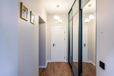 a hallway with a mirror and white walls at One-Bedroom Traku Street Apartment by Reside Baltic in Vilnius