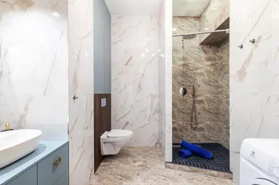 a bathroom with a shower and a toilet and a sink at One-Bedroom Traku Street Apartment by Reside Baltic in Vilnius