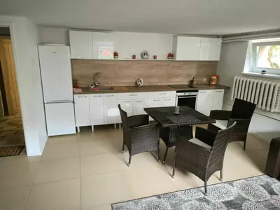 a kitchen with a table and chairs and a refrigerator at Elpo House in Neveronys