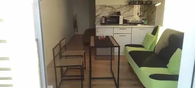 a living room with a table and a couch and a kitchen at Jolantos svečių namai in Rokiškis