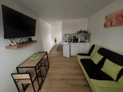 a living room with a couch and a television on the wall at Jolantos svečių namai in Rokiškis