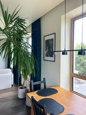 a dining room with a table and a potted plant at Floral Sunshine Apartment in Vilnius