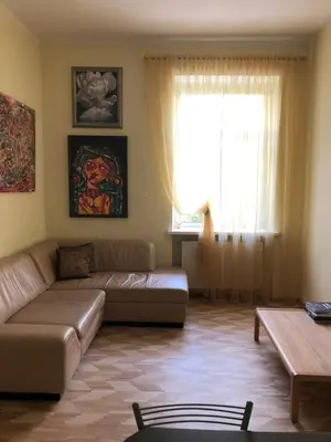 a living room with a couch and a window at Green House Apartment in Kaunas