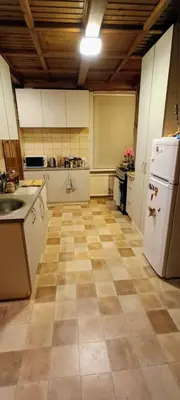 a large kitchen with white appliances and a tile floor at EirForce1 in Kaunas