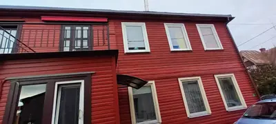 a red house with white windows on a street at EirForce1 in Kaunas