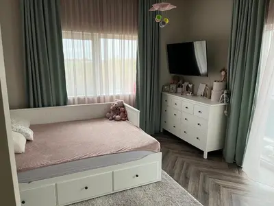 a bedroom with a bed and a dresser and a tv at Cotta in Karkazai