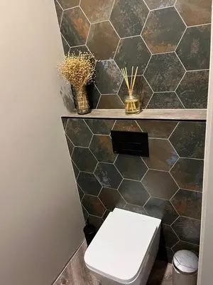 a bathroom with a toilet and a tiled wall at Cotta in Karkazai