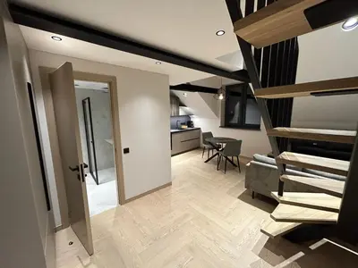 a room with a staircase leading to a room with a kitchen at Studio 11 - old town Kaunas in Kaunas