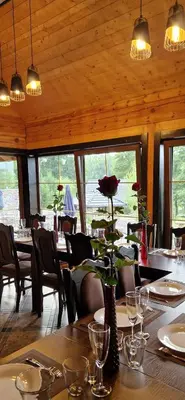 a restaurant with a table with a flower in a vase at Namas su pirtimi Trakai in Salkininkai