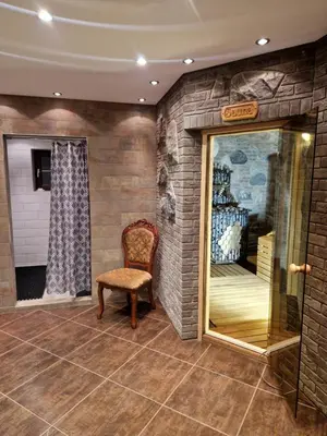 a room with a chair and a brick wall at Namas su pirtimi Trakai in Salkininkai