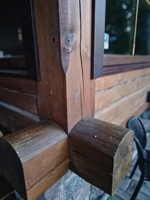 a wooden door with a wooden bench next to a window at Namas su pirtimi Trakai in Salkininkai