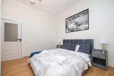 a bedroom with a large bed and a mirror at Spacious Apartment In Vilnius Old Town by Reside Baltic in Vilnius
