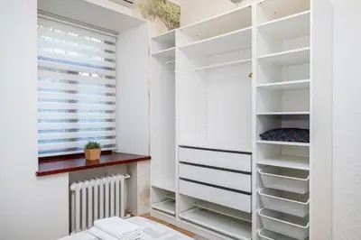 a walk in closet with white shelves and a window at Spacious Apartment In Vilnius Old Town by Reside Baltic in Vilnius