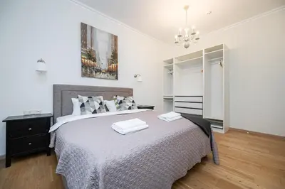 a bedroom with a large bed and a chandelier at Spacious Apartment In Vilnius Old Town by Reside Baltic in Vilnius