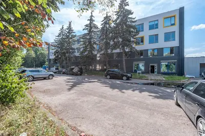 a parking lot with cars parked in front of a building at P-ONE APARTMENTS - Self Check-in in Vilnius