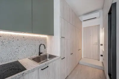a kitchen with white cabinets and a sink at P-ONE APARTMENTS - Self Check-in in Vilnius