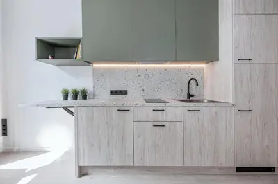 a kitchen with wooden cabinets and a sink at P-ONE APARTMENTS - Self Check-in in Vilnius