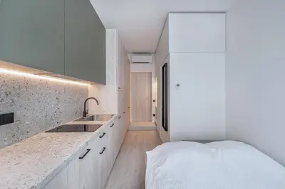 a kitchen with a sink and a bed in a room at P-ONE APARTMENTS - Self Check-in in Vilnius