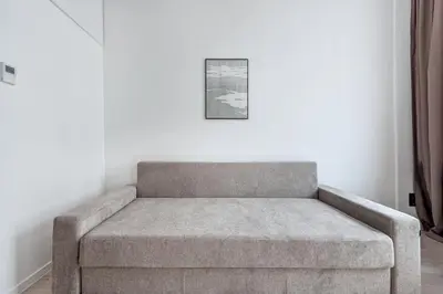 a couch in a room with a picture on the wall at P-ONE APARTMENTS - Self Check-in in Vilnius