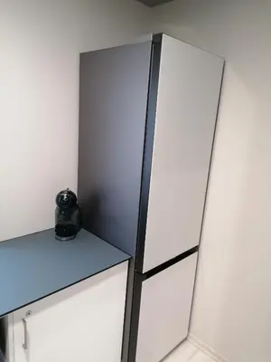a room with a white refrigerator and a table at Čiurlionio 14 in Kaunas