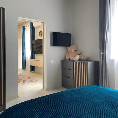 a teddy bear sitting on a dresser in a bedroom at Čiurlionio 14 in Kaunas