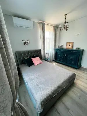 a bedroom with a bed with a pink pillow at Vilties vila in Anykščiai