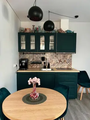 a kitchen with a table with a vase of flowers on it at Vilties vila in Anykščiai