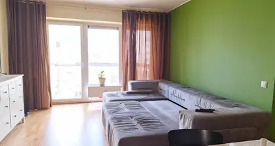 a living room with a couch and a green wall at Butas1 in Vilnius